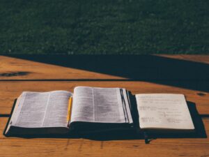 Bible and book on table in shadow
